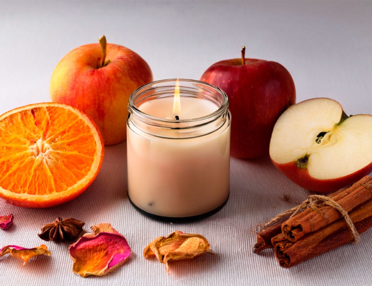 Velas y frutas otoñales sobre mesa blanca